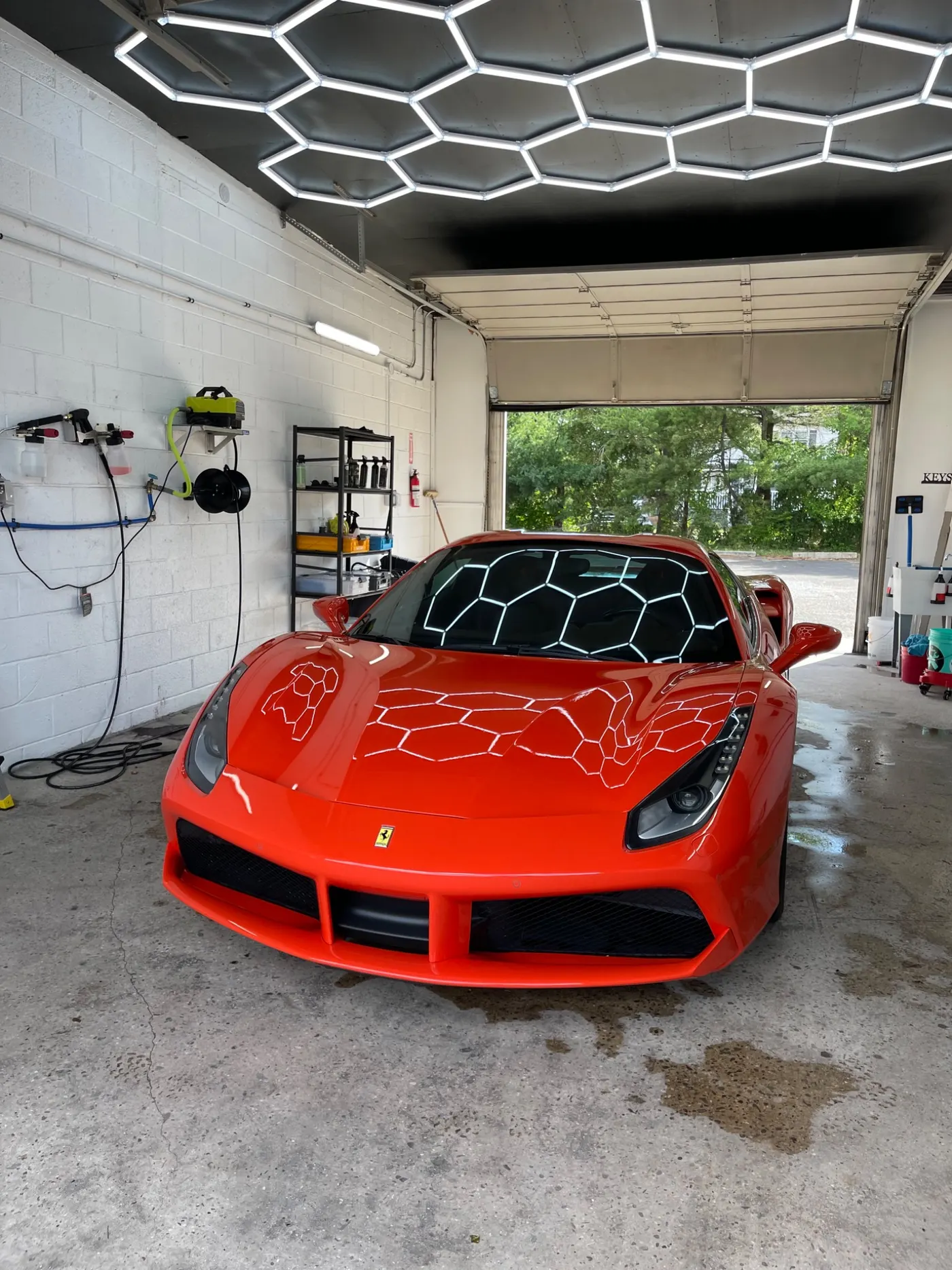 Red Ferrari 488 under the hexagon lights in the Wash Haus shop